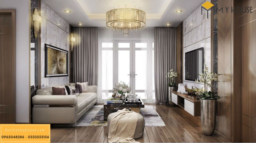 Chiếc sofa màu kem kết hợp hài hòa với chiếc bàn gỗ, thân rỗng, bề mặt bằng chất liệu giả đá sang trọng.
